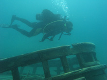 A scuba diver explores the Alice G shipwreck in the clear blue waters of Fathom Five National Marine Park